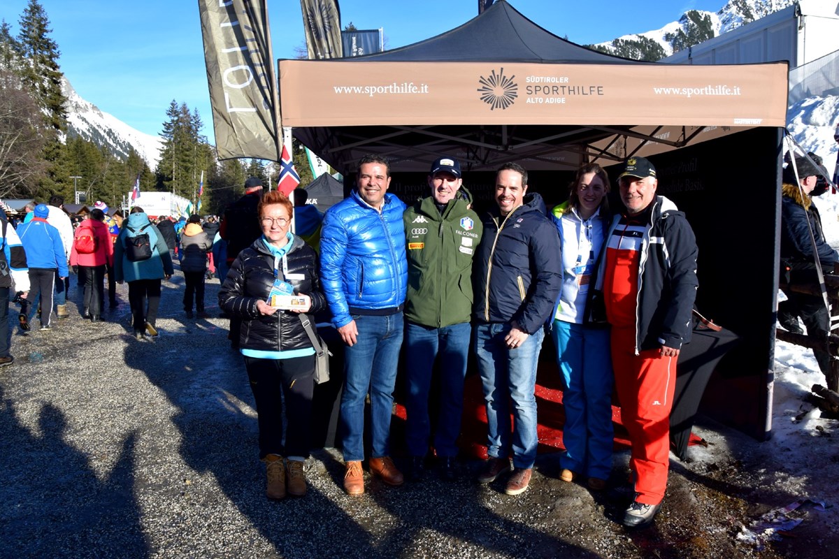 Peter Fill und Armin Zöggeler zusammen mit dem Sporthilfe Präsident Giovanni Podini am Lotterie-Verkaufsstand bei der Biathlon WM in Antholz