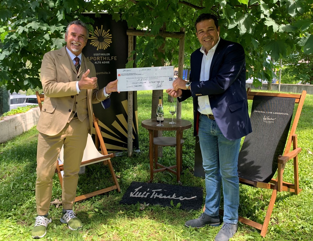 Michi Klemera vom Modelabel Luis Trenker überreicht dem Präsidenten der Sporthilfe Giovanni Podini einen Spendenscheck über 1.500 Euro